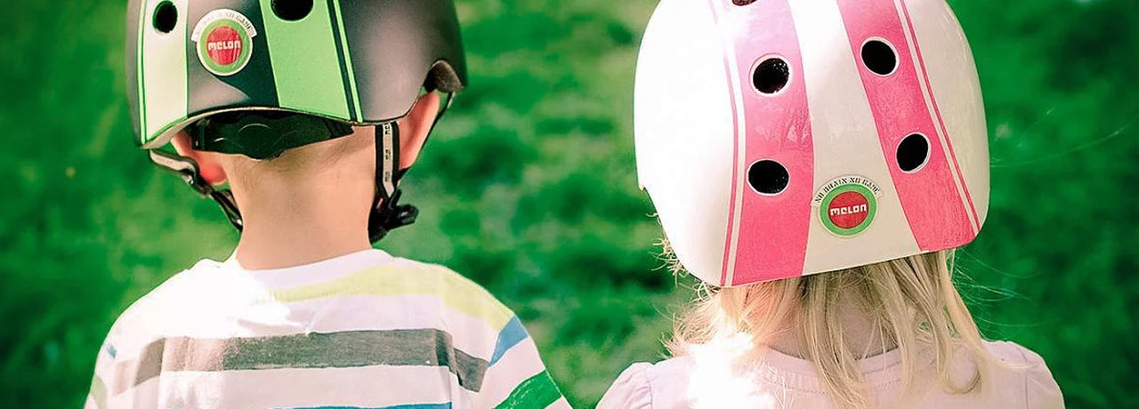 Child with helmet on a wooden balance bike